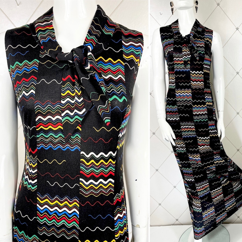 May include: A sleeveless maxi dress with a black background and a colorful wavy pattern. The dress has a tie at the neck.