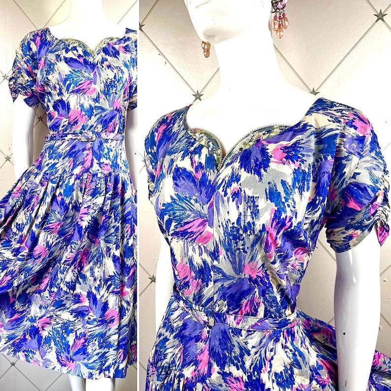 May include: A vintage dress with a sweetheart neckline and short sleeves. The dress is made of a light blue fabric with a pink and white floral print. The dress has a fitted bodice and a full skirt.