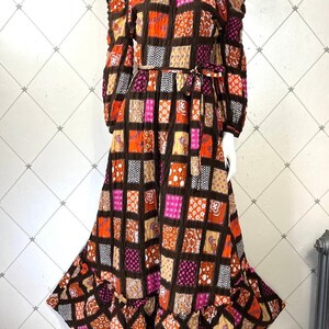 K&ouml;nnte beinhalten: Ein langes, schulterfreies Kleid mit Patchwork-Muster in Braun-, Orange-, Rosa- und Wei&szlig;t&ouml;nen. Das Kleid hat einen R&uuml;schen-Saum und eine Schleife in der Taille.