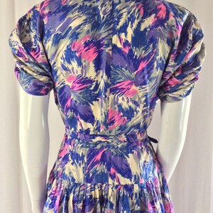 May include: A vintage dress with a floral print in shades of blue, pink, and white. The dress has a fitted bodice and a full skirt. The sleeves are short and puffed.