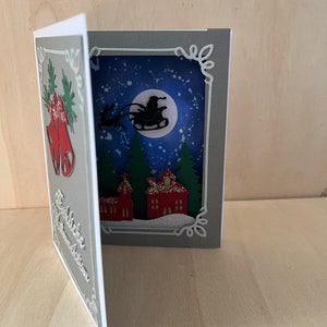 Biglietto di Natale a forma di libro con slitta volante
