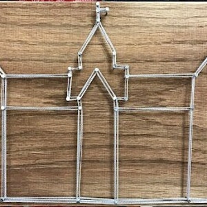 May include: A white string art design of a castle on a wooden background.