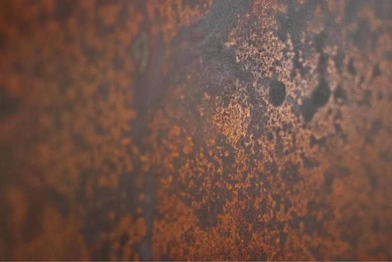 May include: Close-up of a rusty metal surface with a mottled brown and orange color.