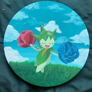 May include: A hand-painted round wooden canvas featuring a green cartoon character with closed eyes and a happy expression. The character is holding a red flower in one hand and a blue flower in the other. The background is a blue sky with white clouds and green grass.
