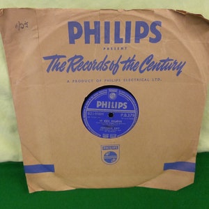 May include: A vintage Philips record in a brown paper sleeve. The sleeve has blue text that reads "PHILIPS PRESENT The Records of the Century." The record label is blue with white text, including "IF YOU BELIEVE" and "JOHNNIE RAY."