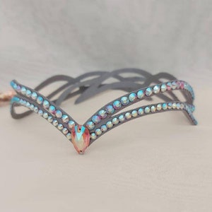 May include: A gray headband with two rows of iridescent rhinestones and a larger iridescent rhinestone in the center.