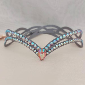 May include: A gray headband with two rows of iridescent rhinestones and a larger, pink iridescent rhinestone in the center.