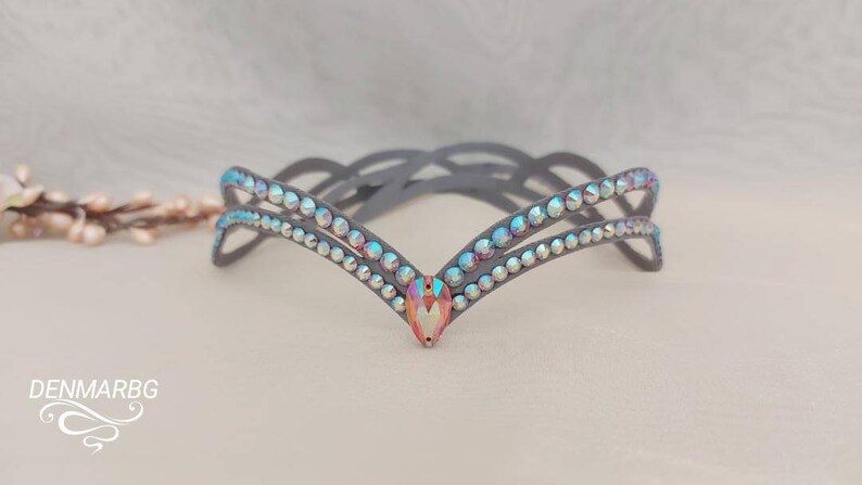 May include: A gray headband with two rows of iridescent rhinestones and a larger, pink iridescent rhinestone in the center.