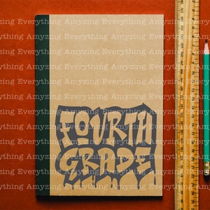 May include: A brown notebook with a green spine. The notebook has the words "FOURTH GRADE" written on it in a black, dripping font.