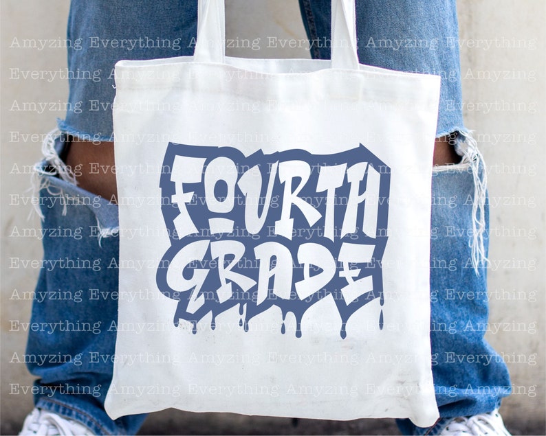 May include: A white tote bag with a blue and white graphic that says "FOURTH GRADE" in a graffiti style font. The bag is being held by a person wearing blue jeans.