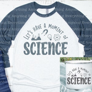 Może przedstawiać: Biało-niebieska koszulka typu raglan z napisem "Let's Have a Moment of Science" w kolorze szarym. Koszulka przedstawia grafikę z kolbą, magnesem, żar&oacute;wką i atomem. Pokazany jest r&oacute;wnież biały kubek emaliowany z tym samym tekstem i grafiką.