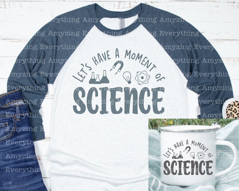 Może przedstawiać: Biało-niebieska koszulka typu raglan z napisem "Let's Have a Moment of Science" w kolorze szarym. Koszulka przedstawia grafikę z kolbą, magnesem, żar&oacute;wką i atomem. Pokazany jest r&oacute;wnież biały kubek emaliowany z tym samym tekstem i grafiką.