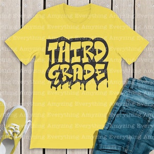 May include: Yellow t-shirt with black text that says "THIRD GRADE" in a dripping paint style. The text is stylized with a graffiti-like font.