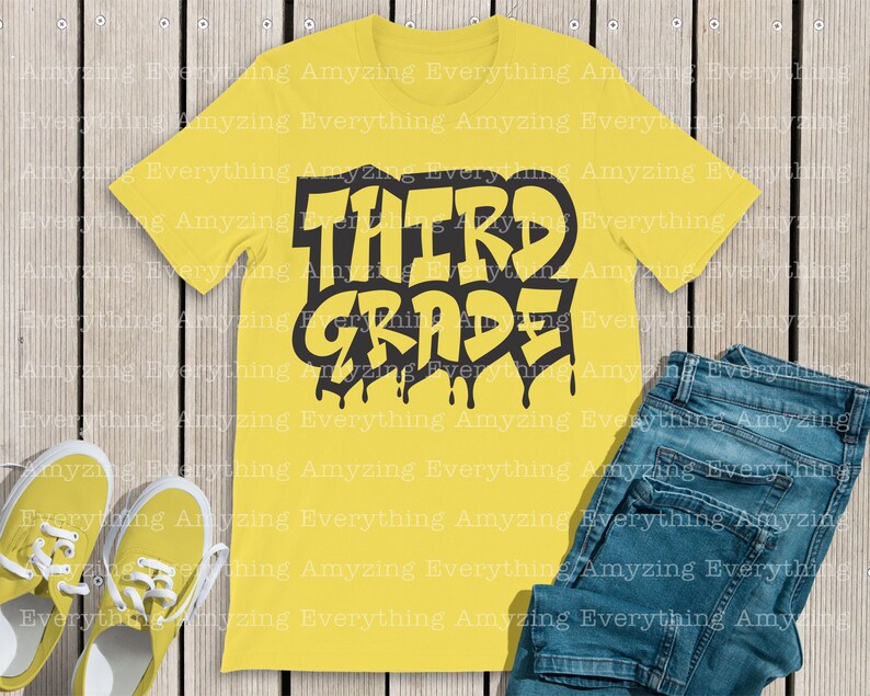 May include: Yellow t-shirt with black text that says "THIRD GRADE" in a dripping paint style. The text is stylized with a graffiti-like font.