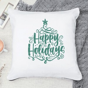 May include: White throw pillow with a teal green design that says "Happy Holidays" with decorative swirls and a star.