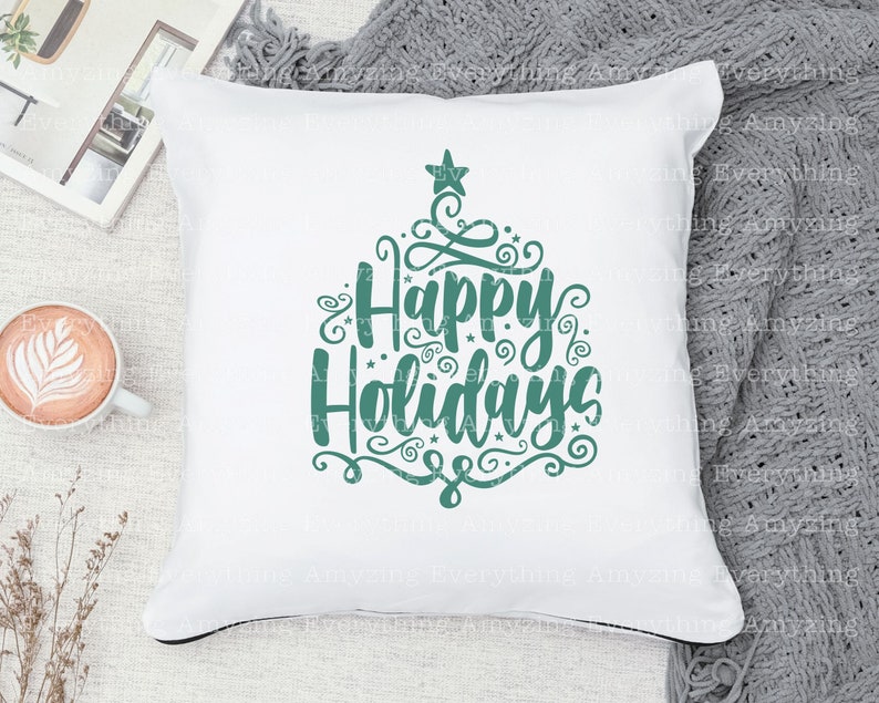 May include: White throw pillow with a teal green design that says "Happy Holidays" with decorative swirls and a star.