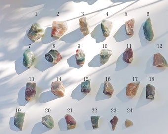 Puede incluir: Veinticuatro piedras de ágata surtidas de color verde, rojo y marrón, numeradas del 1 al 24.
