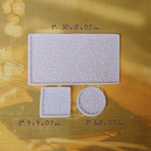May include: Three white silicone molds for making resin crafts. The largest mold is rectangular and measures 30 inches by 17 inches by 0.7 inches. The second mold is square and measures 9 inches by 9 inches by 0.7 inches. The third mold is round and has a diameter of 9 inches and is 0.7 inches thick.