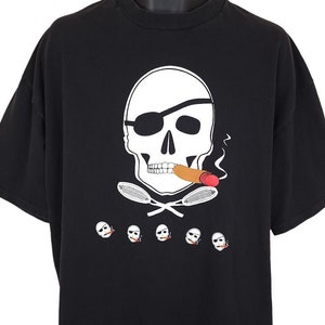 Könnte beinhalten: Schwarzes T-Shirt mit einem weißen Totenkopf- und Knochenkreuz-Design. Der Totenkopf trägt eine Augenklappe und raucht eine Zigarre. Die Knochenkreuze bestehen aus Tennisschlägern.