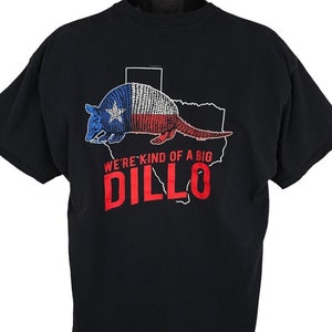 May include: Black t-shirt with a graphic of an armadillo in the shape of Texas with the text "We're kind of a big DILLO" printed on the back.