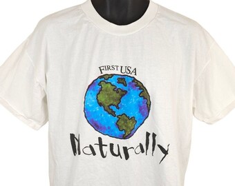 May include: White t-shirt with a blue and green globe graphic and the text "FIRST USA" and "Naturally" in black.