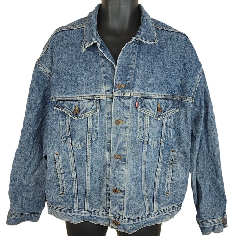 May include: A blue denim jacket with a button closure, two chest pockets, and two front pockets. The jacket has a faded look and is made of a soft, comfortable material.