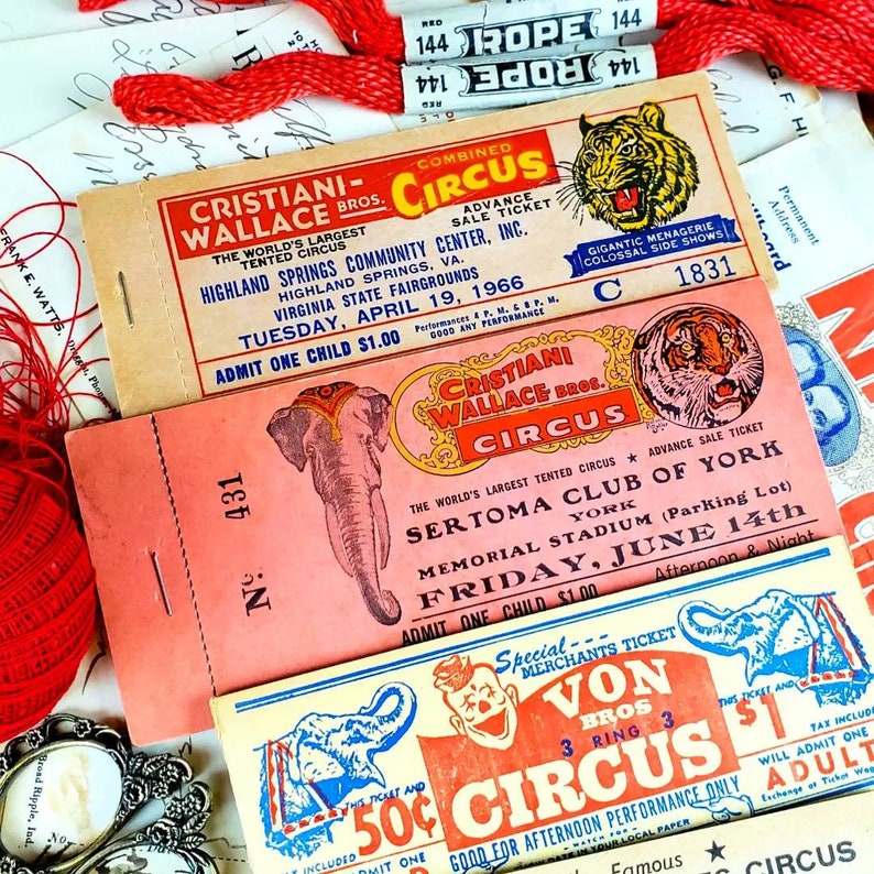 May include: Three vintage circus ticket stubs with red, white, and blue colors. The tickets are for the Cristiani Wallace Bros. Circus, the Sertoma Club of York, and the Von Bros. Circus. The tickets feature images of a tiger, an elephant, and a clown.