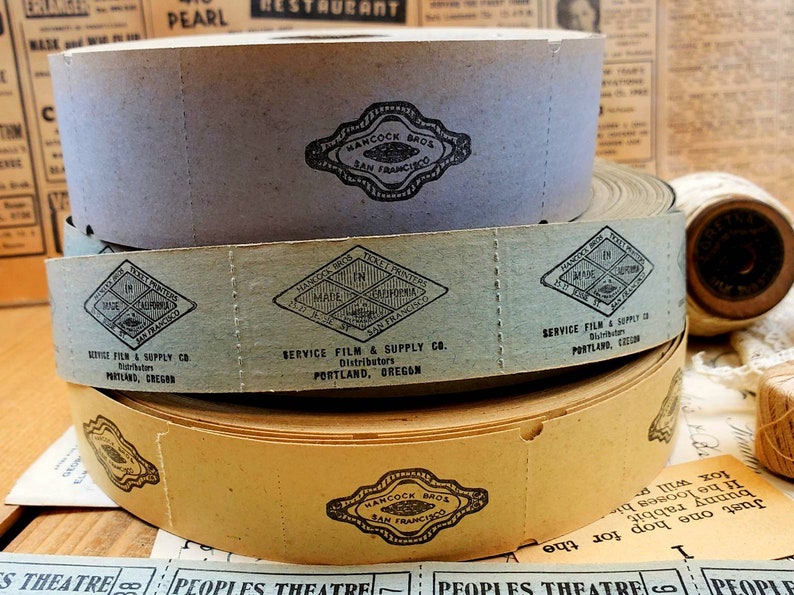 Puede incluir: Tres rollos de pel&iacute;cula vintage con etiquetas que dicen "Hancock Bros. San Francisco" y "Service Film & Supply Co. Distributors Portland, Oregon".