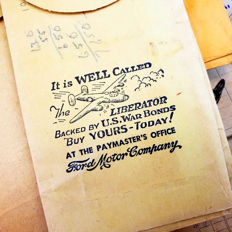 Może przedstawiać: Winietkowa reklama obligacji wojennych USA z czarno-białą ilustracją bombowca Liberator. Tekst głosi "It is WELL CALLED The LIBERATOR BACKED BY U.S. WAR BONDS BUY YOURS-TODAY! AT THE PAYMASTER'S OFFICE Ford Motor Company."