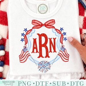 Puede incluir: Camiseta blanca con un diseño patriótico. Presenta un lazo rojo, estrellas azules y banderas americanas. El diseño incluye las letras "ARN" en rojo, con un espectáculo de fuegos artificiales en la parte inferior. La camiseta tiene un dobladillo con volantes y el texto "Monogram Moments".