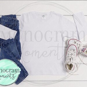 May include: A white long-sleeved t-shirt with a pair of blue jeans and white sneakers. The t-shirt is blank and ready for customization.