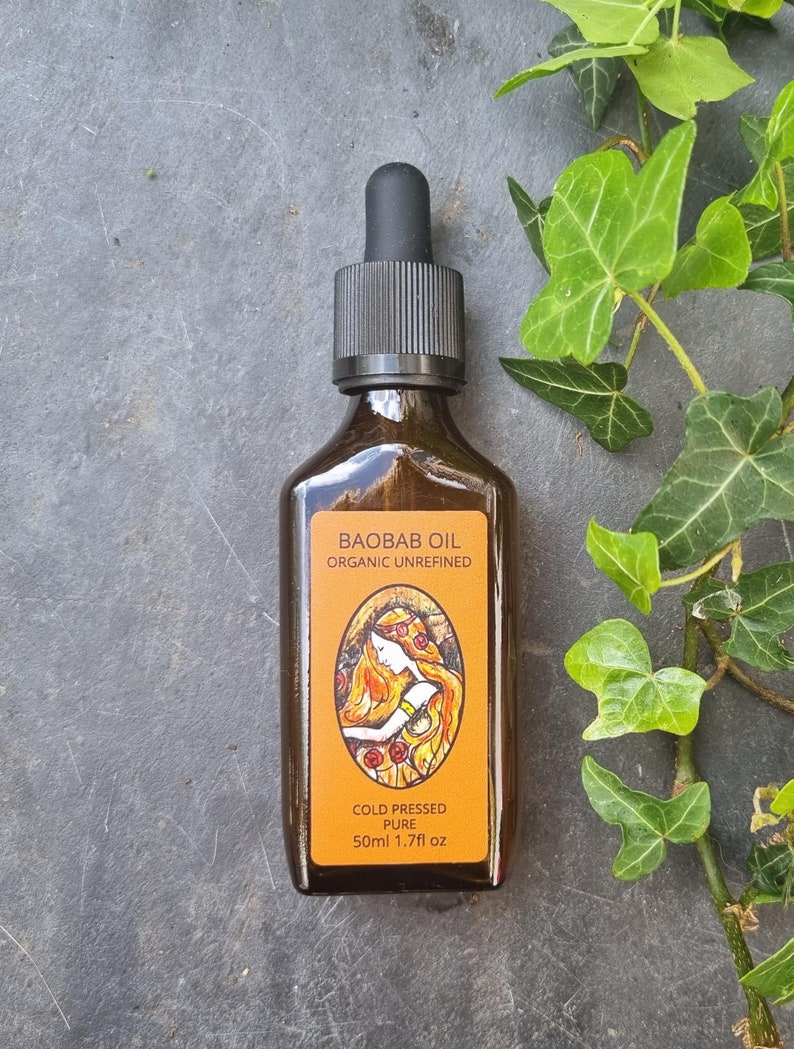 Puede incluir: Una botella de vidrio marr&oacute;n con un gotero negro. La etiqueta dice "Baobab Oil Organic Unrefined Cold Pressed Pure 50ml 1.7fl oz".