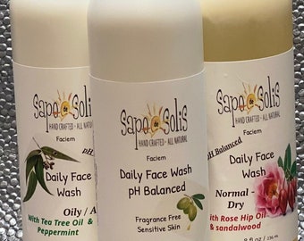May include: Three white plastic bottles of face wash with labels. The bottles are labeled "Sapo de Solis" and each bottle has a different face wash formula: "Oily/A with Tea Tree Oil & Peppermint", "Daily Face Wash pH Balanced", and "Normal-Dry with Rose Hip Oil & Sandalwood". Each bottle contains 8 fluid ounces (236 ml).