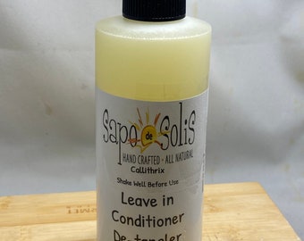May include: A clear plastic bottle with a black spray nozzle and a white label. The label reads "Sapo de Solis", "Hand Crafted All Natural", "Callithrix", "Shake Well Before Use", "Leave in Conditioner De-tangler", and "8 fl oz (237ml)".