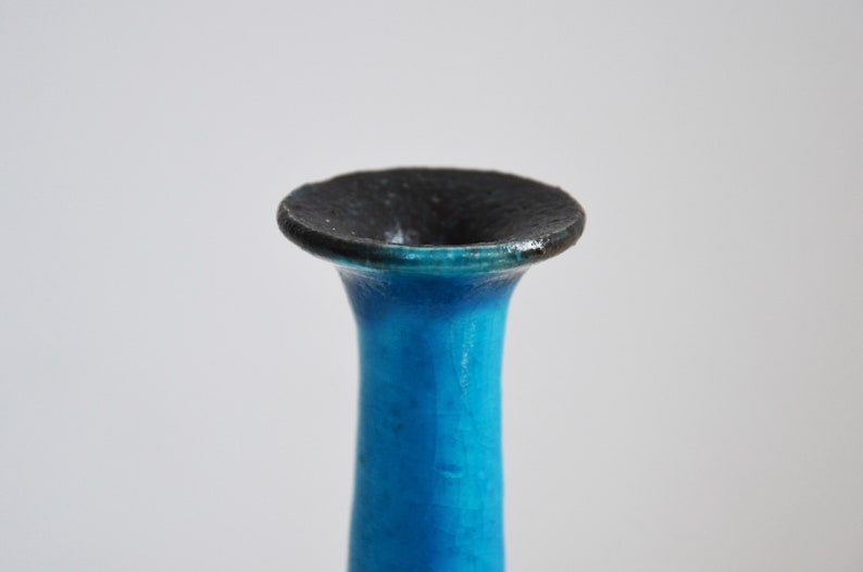 K&ouml;nnte beinhalten: Nahaufnahme der Oberseite einer blauen Keramikvase mit schwarzem Rand.