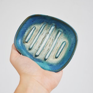 Puede incluir: Un jabonera de cerámica azul y blanca con forma rectangular y un diseño acanalado.