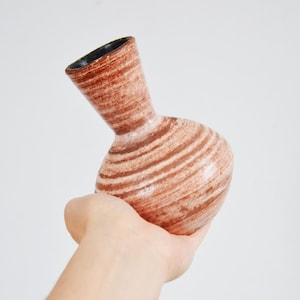 以下が含まれることがあります： 細い首を持つ、茶色と白のストライプ模様の小さな陶器の花瓶