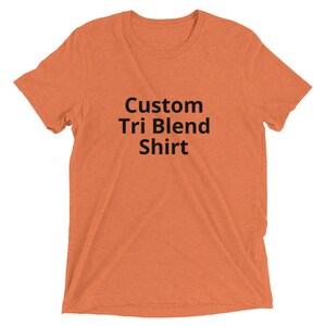 May include: A plain orange t-shirt with the text "Custom Tri Blend Shirt" printed in black.