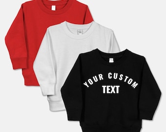 May include: Three sweatshirts in red, white, and black. The black sweatshirt has the text "YOUR CUSTOM TEXT" printed on the front in white.