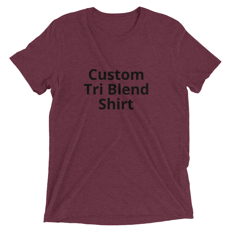 May include: A maroon t-shirt with the text "Custom Tri Blend Shirt" printed in black.