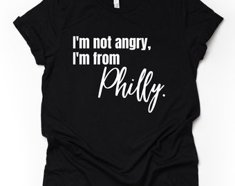 Op de afbeelding: Zwart T-shirt met witte tekst die "Ik ben niet boos, ik kom uit Philly." zegt.