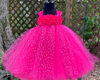 May include: A pink tulle tutu dress with silver glitter and a pink flower embellishment on the bodice.