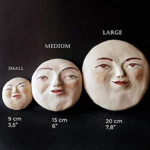 Puede incluir: Tres piezas de decoración de pared de cerámica en forma de luna de diferentes tamaños. La más pequeña mide 3,5 pulgadas, la mediana 6 pulgadas y la más grande 7,8 pulgadas. Cada pieza presenta una cara pintada con ojos, cejas y labios marrones.