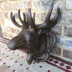 May include: A brown cast iron moose head wall mount with detailed antlers and a textured finish.
