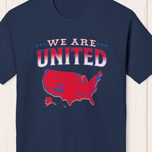 May include: Navy blue t-shirt with a red, white, and blue graphic of the United States map and the text "WE ARE UNITED" in white with red and blue accents.