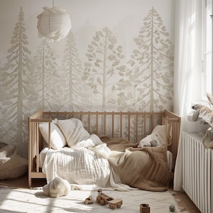 May include: A nursery with a wooden crib, soft bedding, and a forest-themed wallpaper. The crib is filled with white pillows, a white blanket, and a brown blanket. A paper lantern hangs from the ceiling.