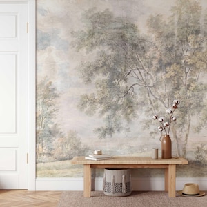 May include: A room with a scenic mural of a landscape with trees and a sky. A wooden bench with a woven top holds a vase with cotton stems, books, and a candle. A woven basket and a straw hat sit below the bench.