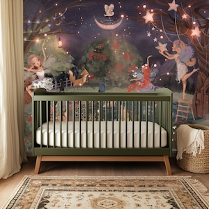 May include: A green crib with a white mattress in front of a mural depicting fairies, animals, and stars. The mural is painted in a whimsical style with soft colors.