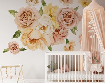 May include: A white crib with a pink and white floral decal on the wall behind it. The crib has a white mattress and a white blanket with a pink and white pattern. There is a pink canopy over the crib.
