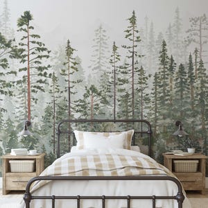 May include: A bedroom with a forest-themed mural. The bed has a dark metal frame, white bedding, and a tan and white checkered blanket. Two wooden nightstands with lamps flank the bed. The mural features watercolor trees in shades of green and brown.